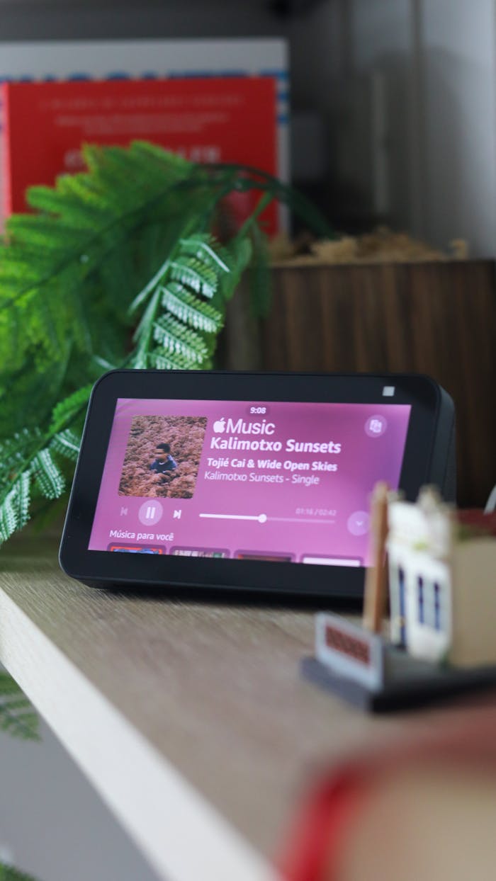 A smart device on a table displaying a music app interface indoors.