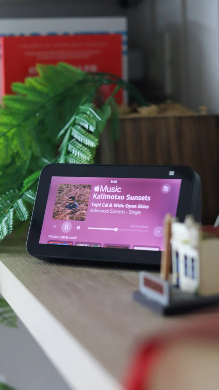 A smart device on a table displaying a music app interface indoors.